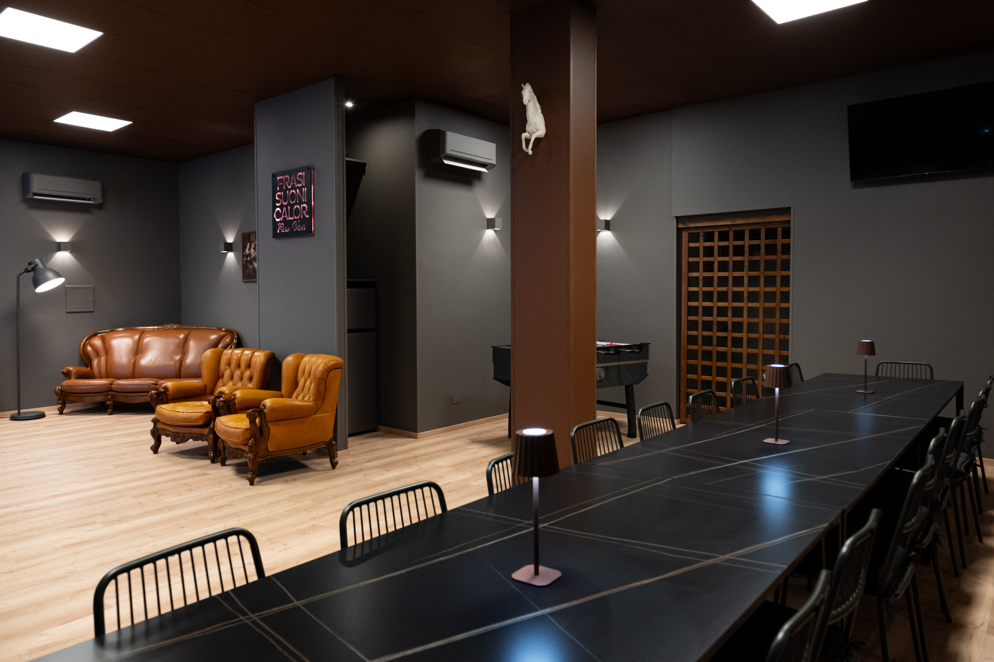 Interno di Para Compartir: tavolo conviviale, poltrone e divano in pelle — lo spazio di Porto Sant'Elpidio per consulenze ed eventi